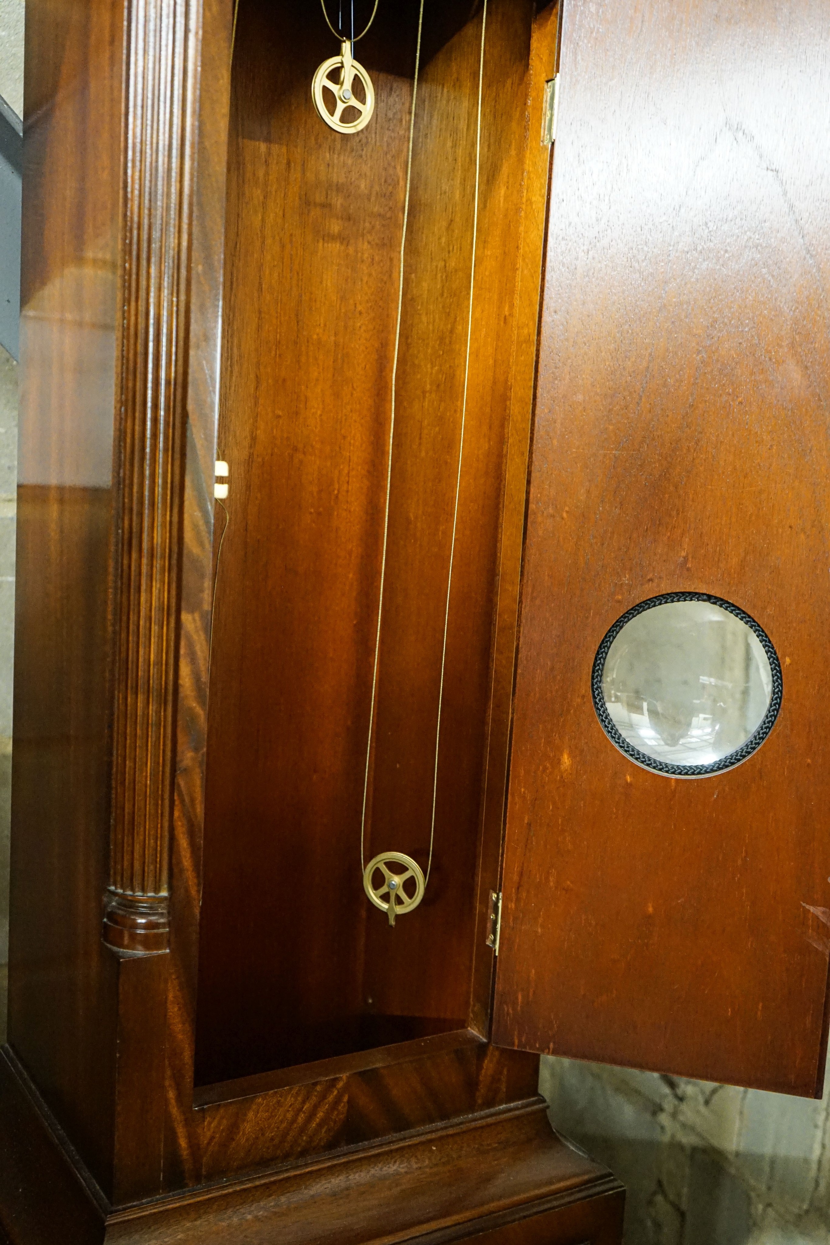 A modern mahogany longcase clock by Comitti London eight day, striking and chiming movement, brass dial with rocking ship automaton, the case with bulls-eye door, height 203cm